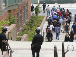 Los Angeles Police officers escort people at the UCLA campus after a fatal shooting at the University of California, Los Angeles, Wednesday, June 1, 2016, in Los Angeles. Los Angeles police chief says shooting at UCLA was murder-suicide. (AP Photo/Damian Dovarganes)
