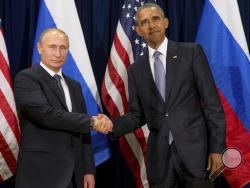 FILE - In this Monday, Sept. 28, 2015 file photo, U.S. President Barack Obama, right, and Russia's President President Vladimir Putin pose for members of the media before a bilateral meeting at the United Nations headquarters. President Barack Obama is promising that the U.S. will retaliate against Russia for its suspected meddling in America's election process, an accusation the Kremlin has vehemently denied. (AP Photo/Andrew Harnik)