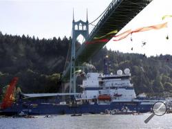 In this July 30, 2015 file photo, the Royal Dutch Shell PLC icebreaker Fennica heads up the Willamette River under protesters hanging from the St. Johns Bridge on its way to Alaska in Portland, Ore. (AP Photo/Don Ryan, File)