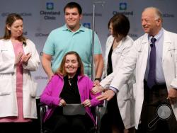 Lindsey and her husband Blake stand with Cleveland Clinic medical staff as they announce she was the nation's first uterus transplant patient, Monday, March 7, 2016, in Cleveland. Standing with the couple, from left, are Ruth M. Farrell, M.D., bio-ethicist, Rebecca Flyckt, M.D., OB/GYN surgeon, and Andreas Tzakis, M.D., program director of the Transplant Center. (Marvin Fong/The Plain Dealer via AP)