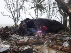 In this image provided by UNICEF Pacific people scour through debris damaged and flung around in Port Vila, Vanuatu, Saturday, March 14, 2015, in the aftermath of Cyclone Pam. (AP Photo/UNICEF Pacific, Humans of Vanuatu)