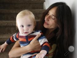 In this Thursday, Oct. 20, 2016 photo, vegan mother Fulvia Serra holds her 1-year-old son, Sebastiano, at home in Fort Collins, Colo. Serra, originally from Italy, and her husband, Scott, are raising their son vegan. (AP Photo/Brennan Linsley)