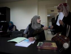 In this Tuesday, March 29, 2016 photo, Palestinian divorce lawyer Reema Shamashneh talks to her client in the Islamic family court in Ramallah, West Bank. (AP Photo/Dusan Vranic)