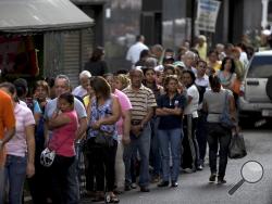 In this Jan. 8, 2015, file photo, shoppers queue outside of a supermarket in downtown Caracas, Venezuela. (AP Photo/Fernando Llano, File)