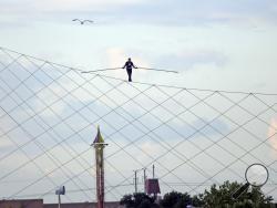 High-wire daredevil Nik Wallenda walks a tightrope above the Milwaukee Mile Speedway at the Wisconsin State Fair in West Allis, Wis. Tuesday, Aug. 11, 2015. Wallenda completed his longest tightrope walk ever during the appearance at the Wisconsin State Fair. (Mike De Sisti/Milwaukee Journal-Sentinel via AP) 