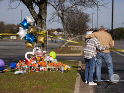 Debbie, left, and Chet Barnett place flowers at a memorial outside of the Chesapeake, Va., Walmart on Thursday, Nov. 24, 2022. Andre Bing, a Walmart manager, opened fire on fellow employees in the break room of the Virginia store, killing six people in the country’s second high-profile mass shooting in four days, police and witnesses said Wednesday. (Billy Schuerman/The Virginian-Pilot via AP)