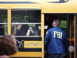 An FBI agent speaks to students on a bus outside of Shoultes Christian Assembly just northwest of Marysville Pilchuck High School in Marysville Friday, Oct. 24, 2014 Students were evacuated by bus to the location after a shooting at the school Friday morning. A student walked into his Seattle-area high school cafeteria on Friday and without shouting or arguing, opened fire, killing one person and shooting several others in the head before turning the gun on himself, officials and witnesses said. (AP Photo)