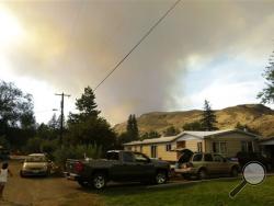 Smoke rises from a wildfire approaching Twisp, Wash., Wednesday, Aug. 19, 2015. Authorities on Wednesday afternoon urged people in the north-central Washington town to evacuate because of a fast-moving wildfire. (AP Photo/Ted S. Warren)