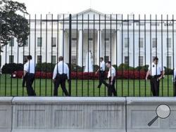 Uniformed Secret Service officers walk along the fence on the North side of the White House in Washington, Saturday, Sept. 20, 2014. The Secret Service is coming under intense scrutiny after a man who hopped the White House fence made it all the way through the front door before being apprehended. (AP Photo/Susan Walsh)