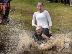Peter Ver Ploeg carries Virginia Petrovek through the mud pit during the North American Wife Carrying Championship, Saturday, Oct. 8, 2016, at the Sunday River Ski Resort in Newry, Maine. The couple, from Portland, Maine, has been married for one year. (AP Photo/Robert F. Bukaty)
