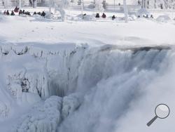 Niagara Falls State Park visitors look over masses of ice formed around the American Falls, photographed from across the Niagara River in Niagara Falls, Ontario, Canada, Thursday, Feb. 19, 2015. (AP Photo/The Canadian Press,Aaron Lynett)