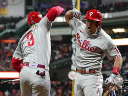 Philadelphia Phillies' J.T. Realmuto, right, celebrates his solo homer with Philadelphia Phillies Bryce Harper during the 10th inning in Game 1 of baseball's World Series between the Houston Astros and the Philadelphia Phillies on Friday, Oct. 28, 2022, in Houston. (AP Photo/Eric Gay)