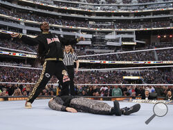In this photo provided by WWE, rapper Snoop Dogg gets ready to drop The People's Elbow on Mike "The Miz" Mizanin during WrestleMania 39 on Sunday, April 2, 2023, at SoFi Stadium in Inglewood, Calif. The rapper stepped in at the last second to perform in the match after Shane McMahon was injured. (WWE via AP)