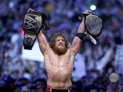 This April 6, 2014 photo provided by the WWE shows Daniel Bryan celebrating after winning the main event during Wrestlemania XXX at the Mercedes-Benz Super Dome in New Orleans. Police say the former WWE champion, Bryan chased two burglary suspects he saw exiting his Phoenix home this week and subdued one until officers arrived. (AP Photo/WWE, Jonathan Bachman)