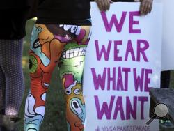 A woman joins others gathering at a starting point before marching for "yoga pants parade" in Barrington, R.I., Sunday, Oct. 23, 2016. Hundreds of women, girls and other supporters proudly donned their yoga pants Sunday afternoon as they peacefully paraded around the Rhode Island neighborhood of a man who derided the attire as tacky and ridiculous. (Kris Craig/Providence Journal via AP)