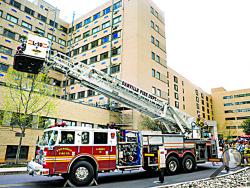 Danville firefighters raise up the ladder outside the Foss Clinic at Geisinger Medical Center in Danville on Tuesday. (Press Enterprise/Bill Hughes)