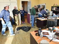 Montour County Commissioner Trevor Finn, second from left, talks with Prothonotary Susan Kauwell as workers with Duraclean Restoration Services – Bill Lundy, left, Jon Morgan, second from right, and Eldon Frey, right – set up large dehumidifiers and buckets for the water in Kauwell’s office Monday afternoon while cleaning up water damage.