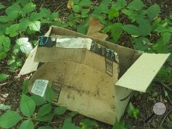 An opened package sits along a trail between Catherine Street and Park Place Village in Bloomsburg. (Press Enterprise/Julye Wemple)