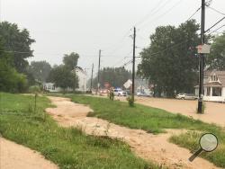 Runoff from a heavy rainstorm overflowed a drainage ditch and Bloom Road at its intersection with Woodbine Lane. (Press Enterprise/Chris Krepich)