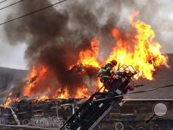 Flames shoot through the roof of the Northumberland County Prison in Sunbury, Pa. on Wednesday, Jan. 14, 2015. Dispatchers say the blaze was reported just after 2 p.m. at the nearly 140-year-old jail in the city of 10,000 about 40 miles north of Harrisburg, Pa. (AP Photo/News-Item, Larry Deklinski)