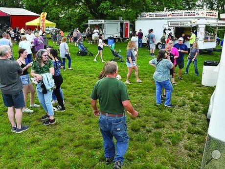 People line up in front of food venders ringing the Mifflinville Carnival Grounds Thursday evening along East First Street in Mifflinville. The carnival runs through Sunday with live music each night and a tractor show Saturday and Sunday. 