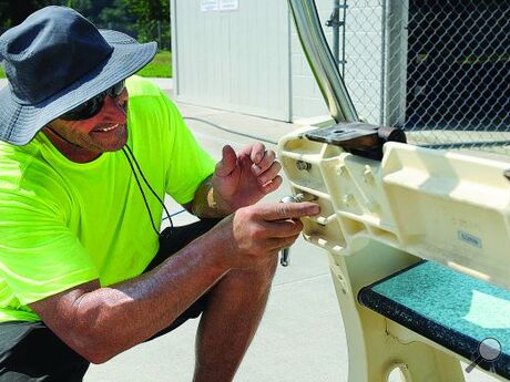 Town laborer Brian Hess works to disassemble the diving board to clean every metal bolt Wednesday morning. Hess and Crew Chief Anthony Silvette cleaned the board and its ground wire so the pool would pass an electrical inspection and reopen.