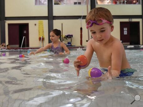 Archie McConaghy, 4, in foreground, and Leni-Mae Sellers, 5, collect eggs floating on the pool water during an aquatic egg hunt Wednesday evening at the Berwick YMCA. Students in 12 sessions over three days will get the chance to collect Easter eggs that either float or sink to the bottom of the pool.