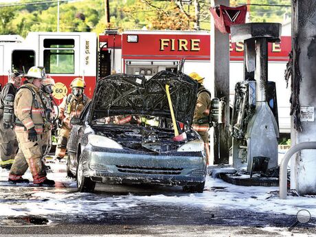 Firefighters from Valley Township, assisted by Liberty and Mahoning townships, extinguish a car fire that spread to a gas pump, at left, at the Mobil station off Route 54. It’s just south of Interstate 80 in Valley Township.