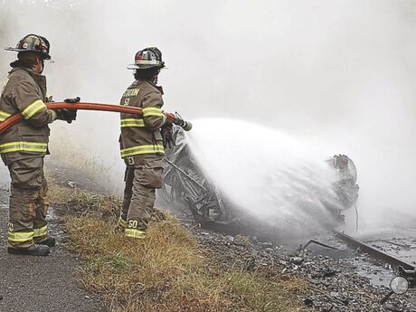 Catawissa firefighters douse a fully engulfed Toyota Corolla after it erupted in flames on railroad tracks along Route 42 near Rupert Wednesday morning after police say it struck the rock wall in the Catawissa Narrows.