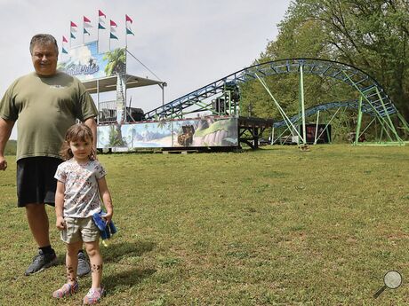 Mike Chorba and his granddaughter, Madilyn Gross, 5, stand by the Tidal Wave roller coaster Friday. Chorba has been restoring the ride at his Mount Pleasant Township home.