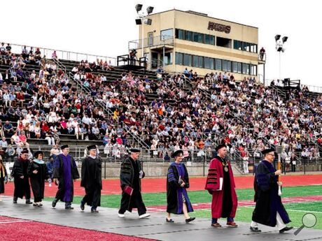 Bloomsburg University professor Michael Hickey carries the ceremonial academic mace and leads the faculty procession onto the fi eld at Robert B. Redman Stadium for morning commencement for the College of Education and the College of Liberal Arts on Sunday. Following Hickey is BU President Bashar W. Hanna.