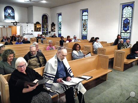 Members of the Beth Israel congregation and guests, above, observe Yom HaShoah, a day of remembrance of the Holocaust, in the Bloomsburg synagogue on Sunday evening.