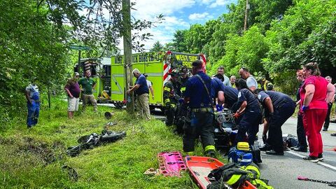 Emergency responders work to revive a motorcyclist who collided with a car at West Rittenhouse Mill Road and Orange Street in Briar Creek Friday afternoon.