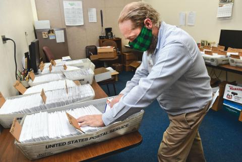 Matthew Repasky, Columbia County chief registrar and director of elections, looks through the absentee/mail-in ballots at the Columbia County Courthouse Annex Monday afternoon. Columbia County sent out 10,232 ballots and has 7,845 returned as of 1:30 p.m. on Monday.