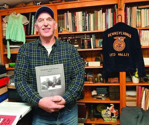 John Marr holds a copy of his book, “Washingtonville, The talk of the Town!” while standing in the museum at his home recently. 