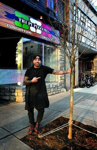 Press Enterprise/Bill Hughes Tri Pi Pizzeria owner Joe Yannone stands by the newly planted tree in front of his Main Street business in Bloomsburg on Saturday.