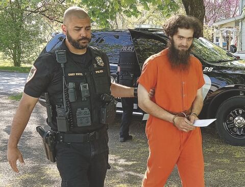 Orange Township Police Chief Dan Patel, left, leads Levi Beiler into district court for a hearing Tuesday morning. Beiler is charged with sexually abusing a child.