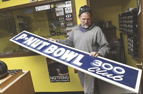 Jason Krum, owner of P-Nut Bowl holds a sign created for bowlers who scored a perfect game at the bowling lanes in Espy. The business shut down Tuesday.