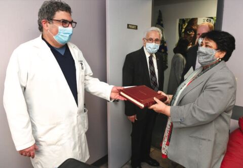 Dr. Albert Alley, left, and father Dr. Ali Alley pass the Articles of Incorporation to Priyam Sharma, CEO of Berwick Hospital, on Friday at the Medical Center on Third Street in Berwick.