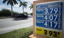Traffic moves past a Doral, Fla. gas station, Wednesday, May 21, 2014. For the third year in a row, the national average will be within a few pennies of $3.64 per gallon. (AP Photo/J Pat Carter)