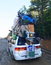  This June 28, 2017, photo provided by New Hampshire State Police trooper Nicholas Iannone shows a vehicle with household goods on its roof, including furniture, boxes and a wheeled basket after New Hampshire State Police pulled over on Interstate 93 near Londonderry, N.H. The agency is asking residents to limit the amount of luggage they place on top of their cars. (Nicholas Iannone/New Hampshire State Police via AP)