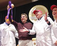 Sylvain Diedrichs, a representative of Savencia Cheese USA of New Holland, Penn., holds the Best in Show winner during the finals of the World Championship Cheese Contest at Monona Terrace in Madison, Wis., Thursday, March 8, 2018. The hard sheep's milk variety called Esquirrou bested 19 other finalists on the final day of the three day event. The contest, hosted by the Wisconsin Cheese Makers Association, is the largest technical cheese contest in the world and this year drew a record 3,402 entries to 121 