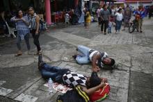 Central American migrants making their way to the U.S. in a large caravan rest lying at the central park in Tapachula, Mexico, Sunday, Oct. 21, 2018. Despite Mexican efforts to stop them at the Guatemala-Mexico border, about 5,000 Central American migrants resumed their advance toward the U.S. border Sunday in southern Mexico. (AP Photo/Moises Castillo)