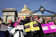 Internal Revenue Service employees Brian Lanouette, of Merrimack, N.H., center right, and Mary Maldonado, of Dracut, Mass., right, join with others as they display placards during a rally by federal employees and supporters, Thursday, Jan. 17, 2019, in front of the Statehouse, in Boston, held to call for an end of the partial shutdown of the federal government. (AP Photo/Steven Senne)