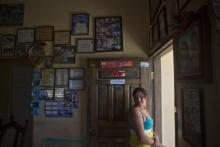 n this Saturday, July 19, 2014 photo, Elsa Ramirez, 27, deported a day earlier from the United States, stands just inside the doorway of her mother's home, in Tocoa, Honduras. (AP Photo/Esteban Felix)