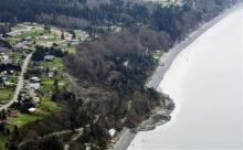 An aerial photo shows a landslide near Coupeville, Wash. on Whidbey Island, Wednesday, March 27, 2013. The slide severely damaged one home and isolated or threatened more than 30 on the island, about 50 miles north of Seattle in Puget Sound. No one was reported injured in the slide, which happened at about 4 a.m. Wednesday. (AP Photo/Ted S. Warren)