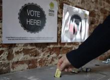 A patron drops a ticket into a voting box at the Original OKRA Charity Saloon in Houston.