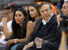 In this photo taken on Friday, Oct. 25, 2013, Los Angeles Clippers owner Donald Sterling, right, and V. Stiviano, left, watch the Clippers play the Sacramento Kings during the first half of an NBA basketball game in Los Angeles. The NBA is investigating a report of an audio recording in which a man purported to be Sterling makes racist remarks while speaking to Stiviano. (AP Photo)