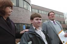 In the March 24, 2005 file photo Patrick Holland, center, stands with his adoptive parents Rita and Ron Lazisky after his adoption was finalized at the Norfolk County Probate Court in Canton, Mass. Holland, 15, was granted a ground-breaking "divorce" from his birth father, Daniel Holland, last summer following his conviction in the murder of Patrick's birth mother. A murder case that prompted Patrick Holland to seek a “divorce” from his father is going before Massachusetts’ top court 18 years after the kill