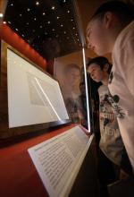 In this Friday, Nov. 15, 2013 photo, school groups and visitors view Illinois' copy of the Gettysburg Address at the Abraham Lincoln Presidential Museum and Library, in Springfield, Ill. (AP Photo/Seth Perlman)